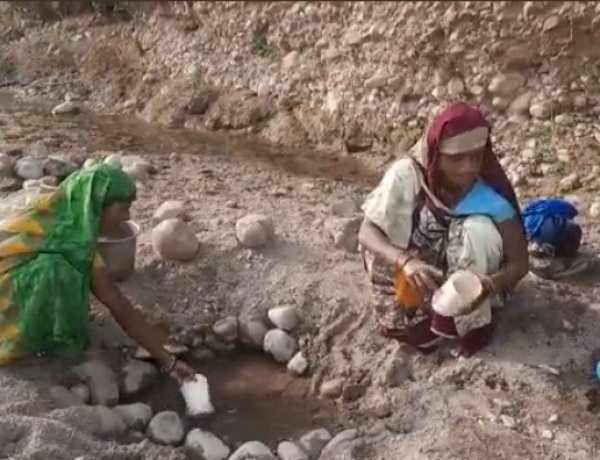 गड्ढा खोदकर पानी की एक-एक बूंद के लिए मशक्कत करते आदिवासी, नर्मदापुरम जिले के केसला गांव की तस्वीर